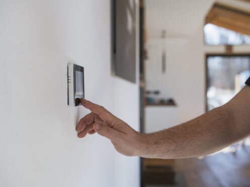 Homeowner adjusting thermostat